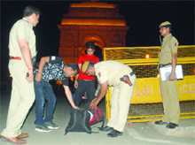 Delhi police officials check bags at India Gate after high alert was declared in the Capital following the Mumbai serial blasts on Wednesday. 