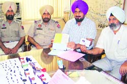 Police officials show fake registration certifi- cates, official stamps and other incriminating documents in Mansa