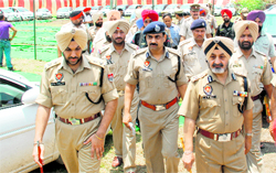 Punjab DGP PS Gill, Ropar range DIG MF Farooqui and Mohali SSP GPS Bhullar with other police personnel at Mohali on Thursday. Some of the stolen vehicles recovered from the accused are seen in the background
