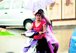Two women on a scooter during rain in Haridwar on Thursday