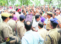 Cloth merchants protest outside the Circuit House in Hamirpur on Thursday.