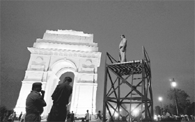 Cops stand guard at the India Gate in New Delhi on Thursday. High alert has been sounded across the country following Mumbai blasts. 