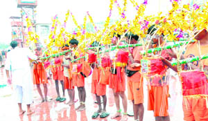 A purohit performs puja as Kanwariyas with decorated kanwars fetch Ganga water at Har-ki-Pauri in Haridwar on Friday