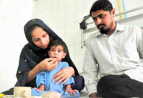 A Pakistani child, Ansharah Batool, with her parents at DMC hospital in Ludhiana.