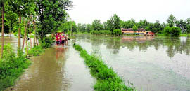 Residents of Lodhipur village wade through flood waters.