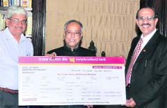 K.R.Kamath (R), Chairman-c um- Managing Director, PNB, along with R Gopalan, Secretary, Economic Affairs, present a dividend cheque of Rs 404.25 crore to Union Finance Minister Pranab Mukherjee, in New Delhi 
