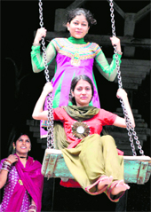 Girls enjoy swings on the first day of the month of sawan at the Rock Garden in Chandigarh on Saturday