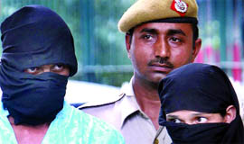 (Above) A man and a woman arrested for kidnapping and selling a 3-year-old child (seen with mother, below) in New Delhi on Saturday.