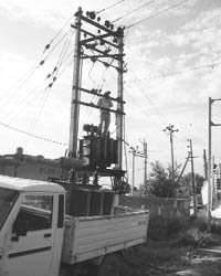 A Powercom employee repairs a transformer at Balongi village 