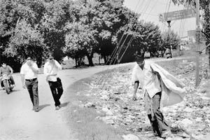 Residents of Kansal cover their nose while crossing a garbage dump at the entry point of the residential area of Nagar Panchayat, Naya Gaon. This place is hardly 100 metre away from the Punjab and Haryana secretariat. 