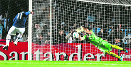 Uruguayan goalkeeper Fernando Muslera (R) stops the penalty kick by Argentinas Carlos Tevez in Santa Fe on Saturday