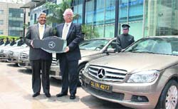 Mercedes-Benz India CEO Peter Honegg (R) hands over a fleet of 90 Mercedes C-Class cars to Rajiv Vij, Managing Director, Carzonrent, in Gurgaon 