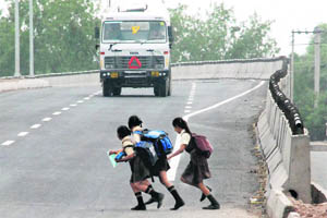 Schoolgirls attempt to cross a road in Panchkula