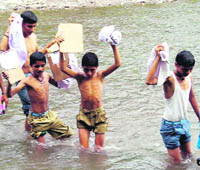 Children cross a rivulet on their way to school at Morni.