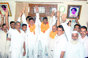 Chief of the Uttarakhand unit of the Bahujan Samaj Party Surajmal (left with garlands) in a jubilant mood at  the party office in Haridwar. 
