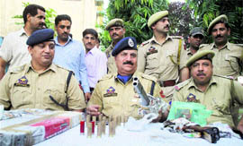 Police officials display recovered weapons in Jammu on Monday.