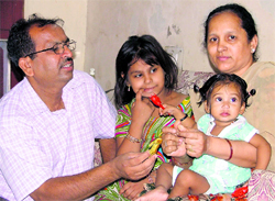 Ten-month-old child sitting in Rajnis lap, while her husband Rajpal Bagga offers the child something to eat in Ludhiana on Monday