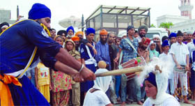 Two Nihang Sikhs perform traditional martial art Gatka during the nagar kirtan in Amritsar.