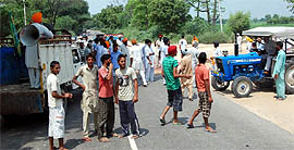 Villagers block the Bathinda-Barnala road at Jethuke village near Rampura Phul on Tuesday.