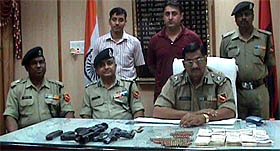 Rajesh Gupta, DIG, BSF, showing arms, ammunition and fake currency notes seized from Mohammad Ishfaq, a Pakistani national.