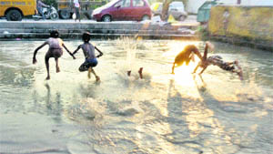 Children jump into a canal to beat the heat in Jammu.
