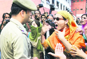 Contractual lecturers of government colleges argue with a police man during a protest in Srinagar on Wednesday.