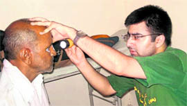 An eye specialist examines a patient at Mohanpur village in Rewari.
