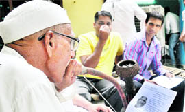 An old man reads a pamphlet distributed by the Anna Hazare team in New Delhi on Thursday.