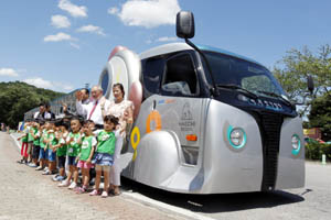 People pose in front of a wireless electric tram during its launch ceremony at Seoul Grand Park in Gwacheon, south of Seoul.