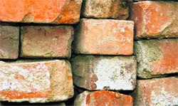 Second-hand bricks are removed from the debris of dismantled buildings