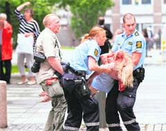 Policemen evacuate an injured woman after a powerful explosion rocked central Oslo