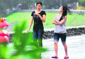 Young girls enjoy the cool breeze and drizzle at the Sukhna Lake in Chandigarh on Saturday.