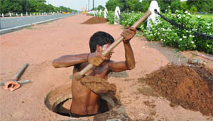 An NDMC worker cleans a sewer at Rajpath in New Delhi