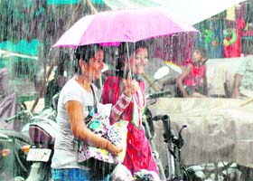 Two girls enjoy themselves in heavy rain in Dehradun on Saturday morning