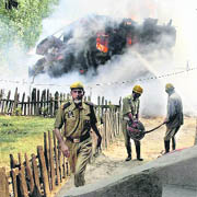 Firemen try to extinguish a fire at a house, where three militants were killed by the security forces, in Handwara