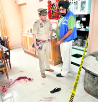 Policemen investigate the site where a robbery took place at Rishi Nagar in Ludhiana.
