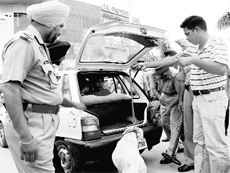 A dog squad conducts a search operation for security purposes ahead of Independence Day celebrations outside Paras Down Mall at Zirakpur on Sunday