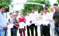 Candidates show their roll numbers in front of Shishu Niketan Modern Senior Secondary School at Sector 22 in Chandigarh on Sunday