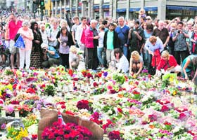 UNITED IN GRIEF: People gather outside a church following a mass for victims in Oslo on Sunday