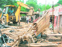 NHAI employees demolish encroachments near the Attari-Wagah joint check post on Monday