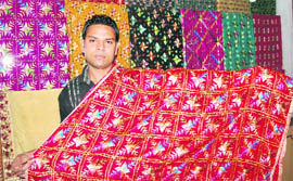 A worker shows a phulkari design at a shop in Patiala