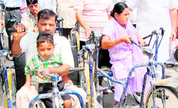 Disable persons get tricycles in Amritsar on Tuesday. Inderbir Bulariab, Parliament Secretary, (not in picture) distributed the tricycles among the needy