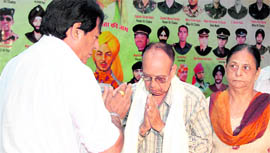 Former Punjab minister Avtar Henry honours the parents of Kargil war martyr Major Kapil Vinayak on Vijay Divas in Jalandhar on Tuesday.