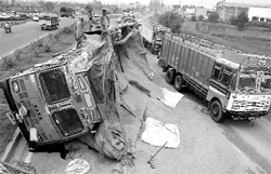 Workers unload hay from a truck that overturned while saving a stray animal on the Zirakpur highway on Wednesday. The traffic remained stalled for hours after the incident
