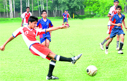 A defender kicks the ball during a match at St Johns High School in Chandigarh on Wednesday