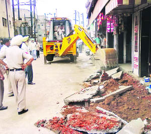 A demolition squad of the Municipal Corporation razes illegal structures at Dashmesh Nagar in Ludhiana