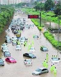 Floodwaters submerge cars on a road after heavy rains hit the Seoul region on Tuesday