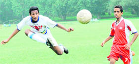 A player passes the ball to his teammate during the final of St. Johns Football Tournament in Chandigarh on Thursday.
