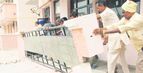 Employees of the UT Estate Office remove an encroachment from a house in the Milkfed Employees Cooperative Society, Sector 49, Chandigarh on Thursday.