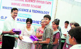 Deputy Commissioner Rajnikanthan gives away prizes to the selected students at a science exhibition in Kurukshetra.